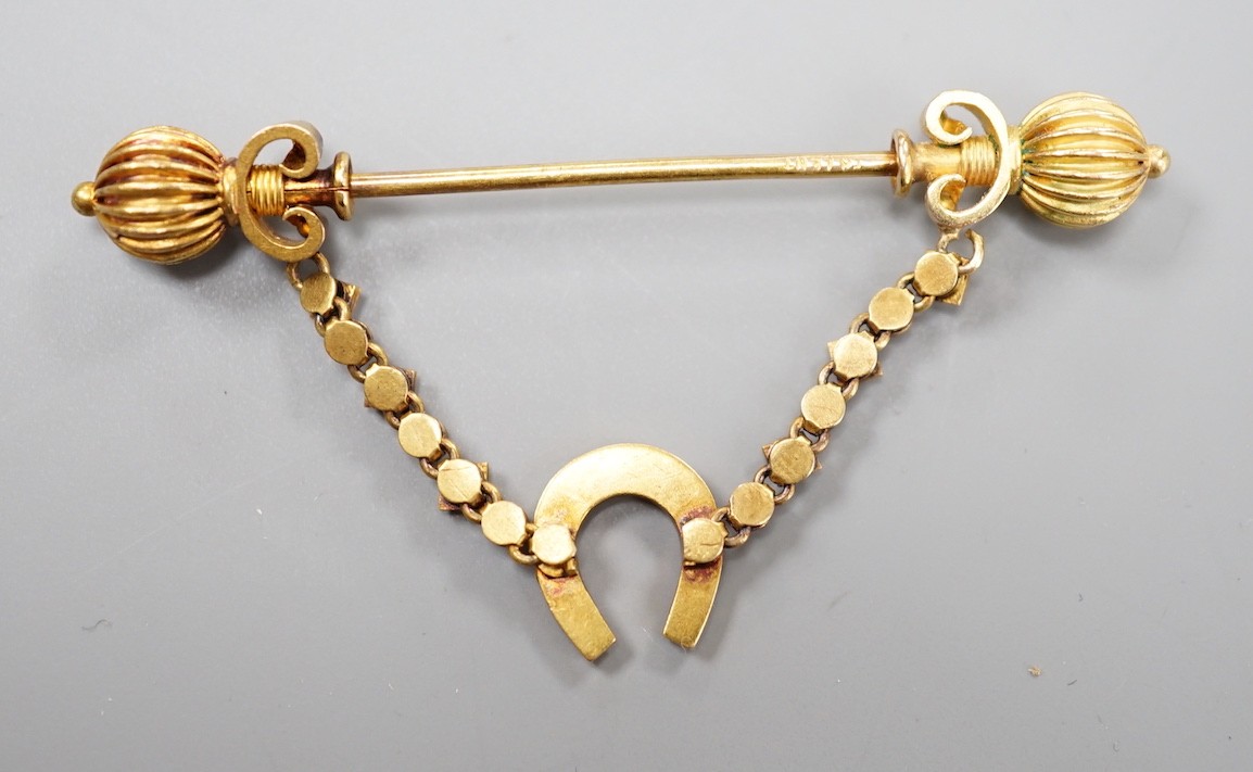 An early 20th century yellow metal and seed pearl horseshoe swag jabot pin, 59mm, gross weight 4.9 grams (pearl missing).